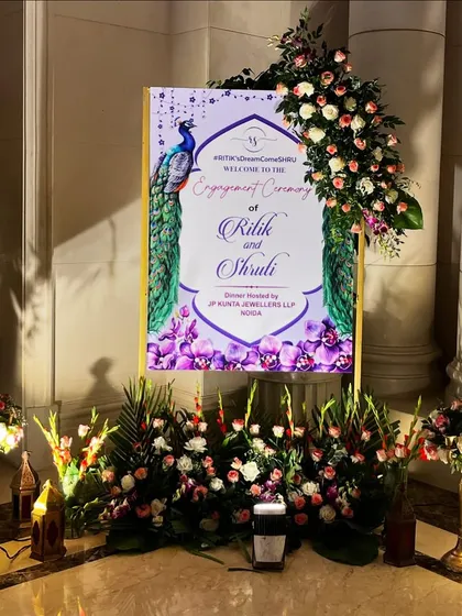 A custom welcome sign for Ritik and Shruti's engagement at The Leela Palace, featuring a beautiful peacock design.
