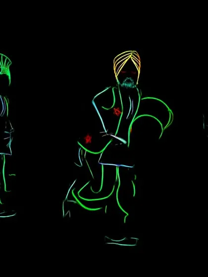 A still image capturing the essence of our Bhangra Tron act. The glowing outlines of the dancers in traditional poses create a beautiful and dynamic visual against the black background.