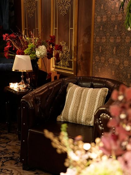 A comfortable lounge setting within one of the "train compartments." We used classic leather armchairs, intricate gold-cutwork panels, and warm lamplight to create an authentic, cozy atmosphere.