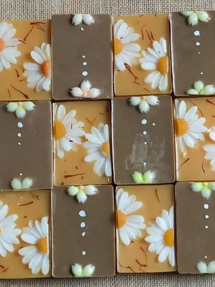 A collection of daisy-themed soaps in earthy tones.