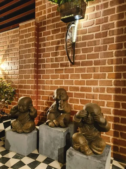 See no evil, hear no evil, speak no evil. Our 'Lucu' monk statues bring a touch of wisdom and whimsy to this client's entryway, set against a rustic brick wall.