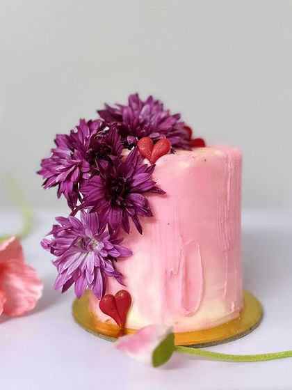 A beautiful tall mini cake from my Valentine's collection, featuring soft pink ombre buttercream and topped with a crown of fresh purple chrysanthemums.