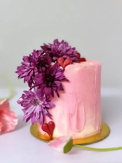 Another design from the Valentine's collection. This tall mini cake has a soft pink watercolour finish and is crowned with fresh purple flowers.