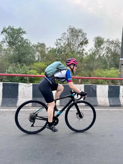 A side profile of a member riding with a backpack, prepared for a long journey.