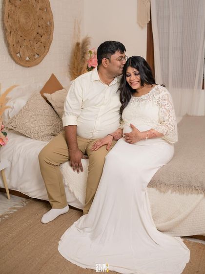 A tender moment with the father-to-be kissing his wife's forehead.