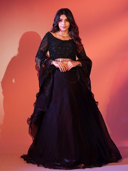 You can never go wrong with a classic black lehenga. This one features a sequined blouse and flared sleeves for a touch of modern drama, perfect for an evening reception.