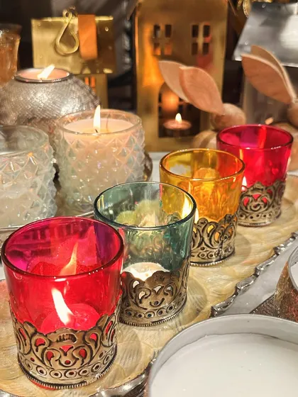 A close-up of my colorful glass votives with intricate metal bases. These are perfect for adding pops of color and a warm glow to your Diwali or Christmas decor.