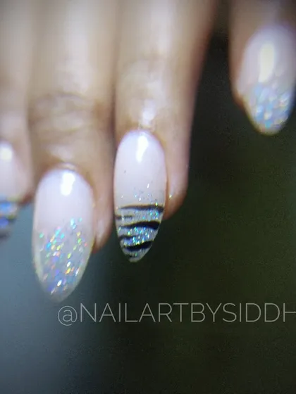 A close-up of this chic design, featuring a mix of holographic glitter and a striped accent nail.