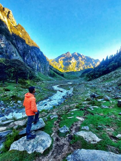 A trekker looking out over the stunning valley at sunrise on the Hampta Pass trek.