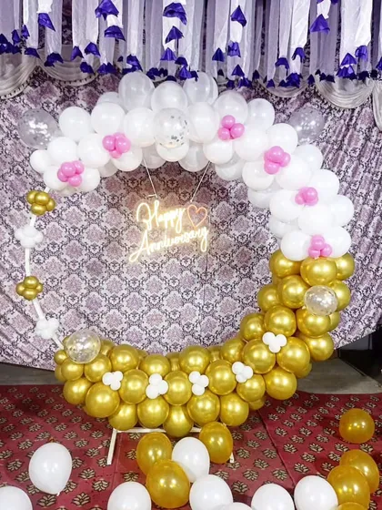 Another angle of the circular anniversary balloon arrangement, showing the mix of metallic gold and matte white balloons.