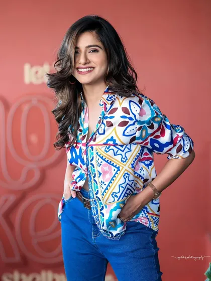 A vibrant lifestyle portrait for a Sandalwood actress. We chose a colorful cafe setting and a casual, modern outfit to capture a bright and approachable personality. This style is excellent for actor headshots or social media content that feels authentic and lively.