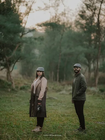 A striking portrait of the couple in a misty forest, their classic attire and confident poses creating a powerful, vintage-inspired image.