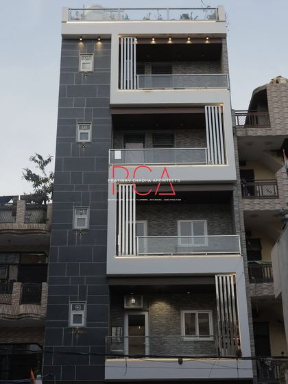 A straight-on daytime photograph of 'The Cursive Abode'. This perspective offers a clear and comprehensive look at the facade's balanced composition and material selection.