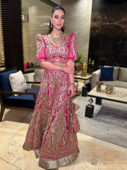 The full festive look, showcasing the vibrant pink lehenga and the makeup that balances the bold outfit with sophisticated glam.