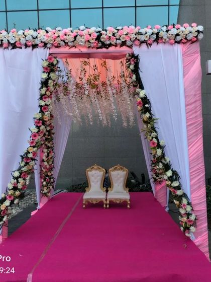 A beautiful seating area for the couple inside a floral archway. This provides a lovely, decorated space for them to sit during certain rituals.
