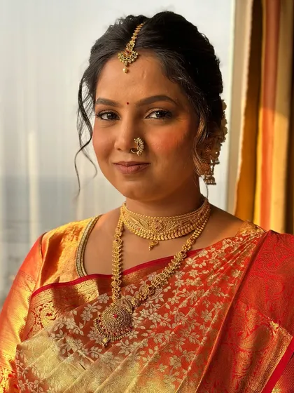 A close-up portrait of the South Indian bride, showcasing the traditional gold jewelry and the soft, radiant makeup I created for her.