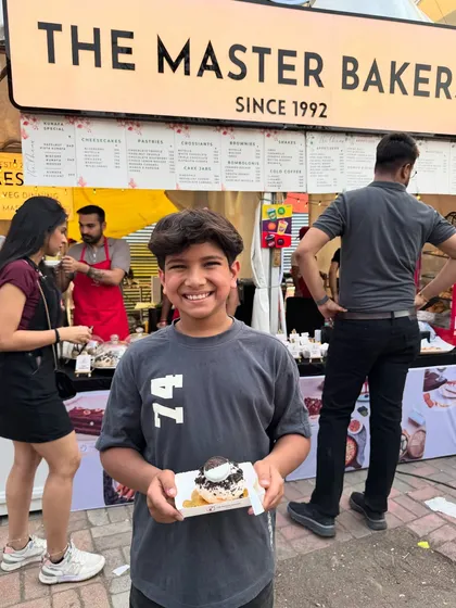 Smiles, sweets, and satisfied cravings. A happy young customer enjoying one of our donuts at our stall at the Horn OK Please festival.