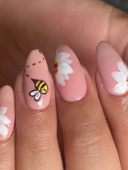Bee-autiful, isn't it? A sweet little hand-painted bee buzzing towards daisies on a lovely pink base. This is what delicate, custom nail art is all about.
