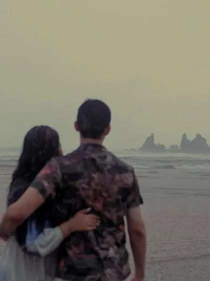 A quiet, reflective moment as a couple looks out at the sea during a rainy day in Goa. It's not just about the laughter; it's also about capturing the peaceful, intimate connection between two people.