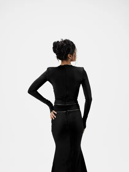 A view from the back, showcasing the intricate structure of the messy high bun. This type of editorial hairstyling is designed to look effortlessly chic from every angle.