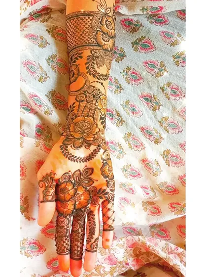 This design combines a variety of elements, including florals, paisleys, and jaal work, to create a rich and textured full-hand design.