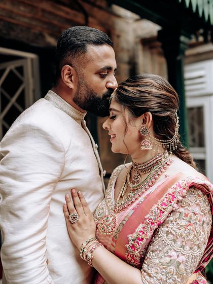 An intimate portrait of my husband and me. My pink Kanchipuram silk saree with a fully embroidered blouse is paired with his custom-designed embroidered bandhgala.