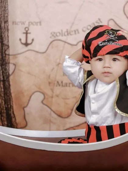 Adjusting his pirate bandana, this little captain is getting into character. We provide a range of costumes and accessories to make our themed shoots feel authentic and fun.
