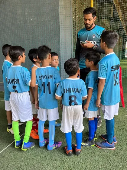 A coach giving a team talk to the U-9s, ensuring every player is on the same page before a match.