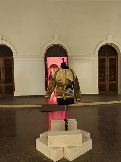 A custom jacket displayed as an art piece at the same event. This shows how fashion can be presented in a gallery or installation context.