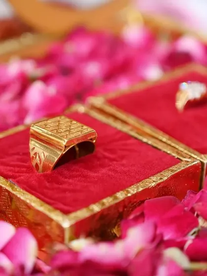 A close-up shot of the engagement rings nestled in their boxes on a bed of rose petals, symbolizing the start of a new journey.