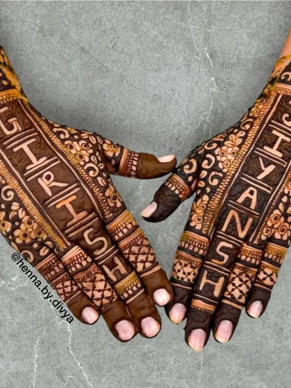 A unique back-hand design where the couple's names, 'Girish' and 'Jiyansh', are written vertically down the hands. The floral background adds a touch of elegance.