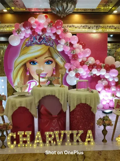 For this first birthday, I created a glamorous Barbie theme. The setup includes a large circular Barbie backdrop, a cascading pink balloon arch, and a custom light-up marquee name for the birthday girl.