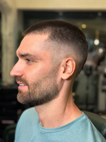A close-up of a short buzz cut with a fade. The blend is seamless from the skin up to the hair on top.