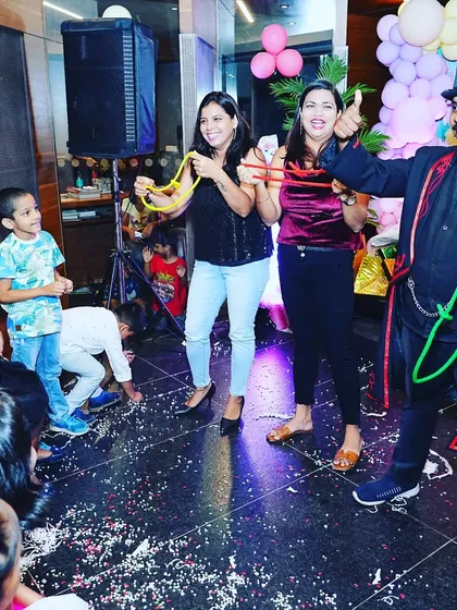 A thumbs up for a successful trick. The volunteers and the audience are all enjoying the interactive magic at this birthday party.
