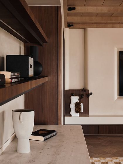 A detail shot of a study area, showcasing our focus on clean lines and curated objects. The combination of dark wood shelving and a white ceramic vase creates a simple yet elegant composition.