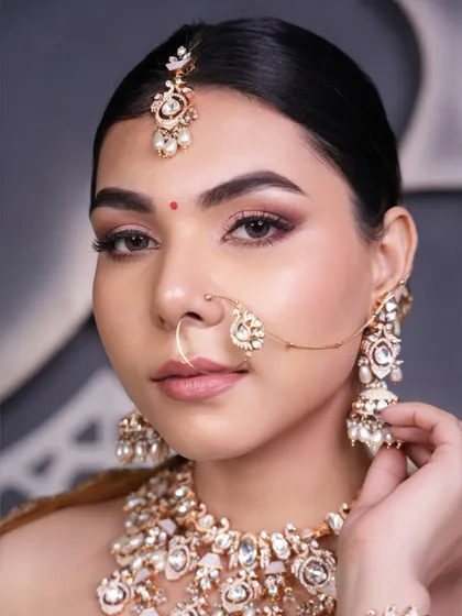 This client's sleek updo is perfect for showcasing her beautiful features and stunning Polki jewelry. It's a timeless choice for a wedding or reception.
