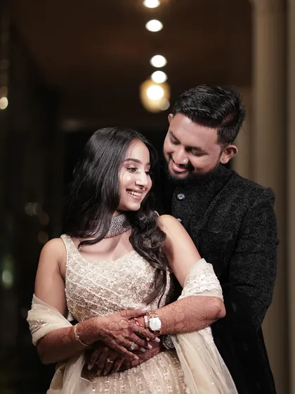 A sweet, smiling portrait of the couple. Her makeup is soft and glamorous, perfect for an evening celebration.