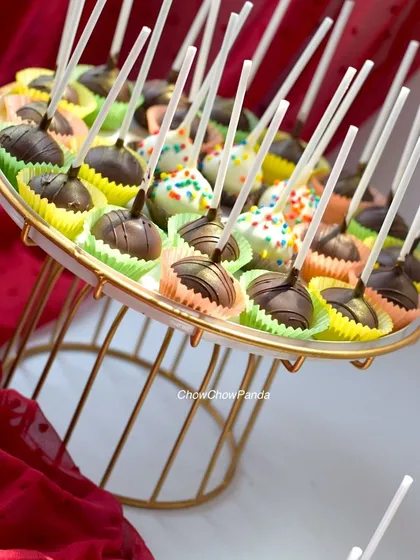 A display of my assorted cake pops on a two-tiered stand. This order included both plain chocolate and white chocolate pops with rainbow sprinkles.