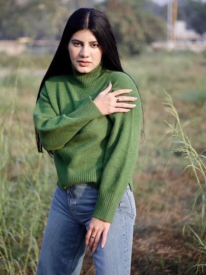 This pose highlights the sleeve detail and fit of the sweater, useful for apparel photography.