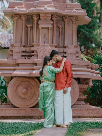 An intimate pre-wedding photo in front of a stone chariot structure, reminiscent of Hampi. This is a great example of our unique, culturally rich locations.