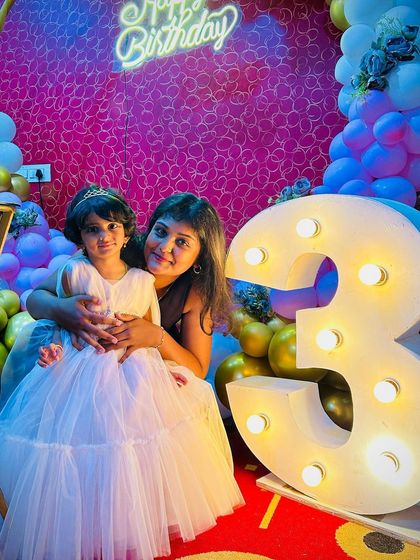 Capturing a sweet moment at Cherry's 3rd birthday party. Our decor included a large light-up marquee number and a vibrant balloon garland, creating the perfect photo corner.