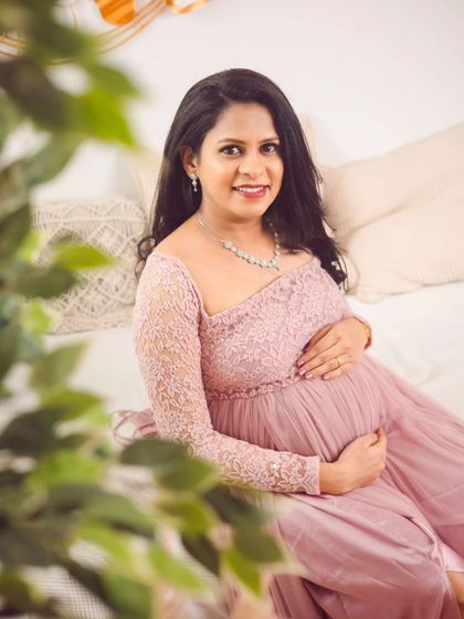 A close-up portrait that captures the joy and beauty of pregnancy. The soft lighting and delicate lace gown create a warm and intimate feel.