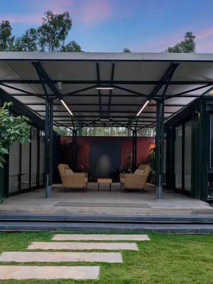 A container office at dusk, with an open-air central seating area. This image highlights the innovative use of space, creating a collaborative and relaxed workspace that is connected to the outdoors.