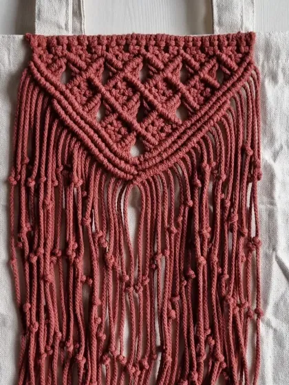 A full view of the macrame panel on the canvas tote bag. It adds a unique, handmade, and bohemian touch to a practical, everyday item.