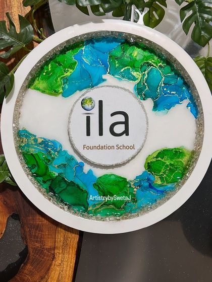 The sign with the light off, showing the vibrant colors and delicate gold details of the alcohol ink art.