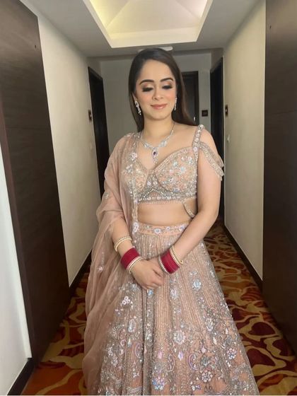 A bride ready for one of her pre-wedding functions, with her hair styled in simple, elegant, open waves. This look is perfect for a Roka or engagement ceremony.