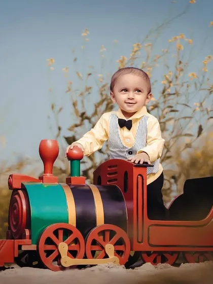 A dapper little gentleman ready for a train ride. The bowtie and vest add a touch of class to this fun, outdoor photoshoot.