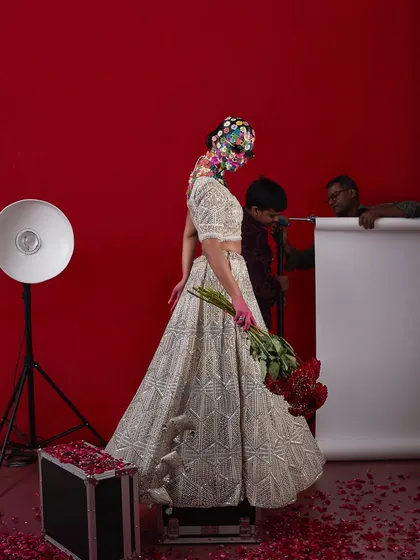 A behind-the-scenes shot of the "flower head" bridal look, showing the scale and creativity of the concept.