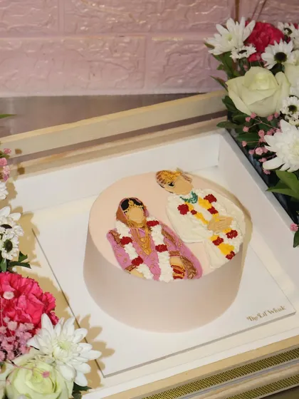 A closer look at the hand-piped portrait cake from our anniversary hamper, capturing the couple in their traditional wedding attire.