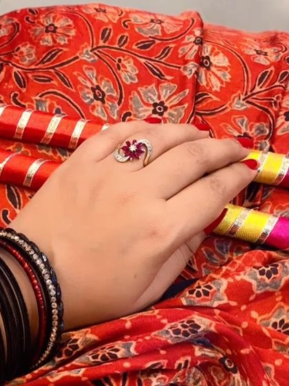 A detail shot of the hands holding dandiya sticks, adorned with bangles and a ring, highlighting the importance of accessories in festive wear.